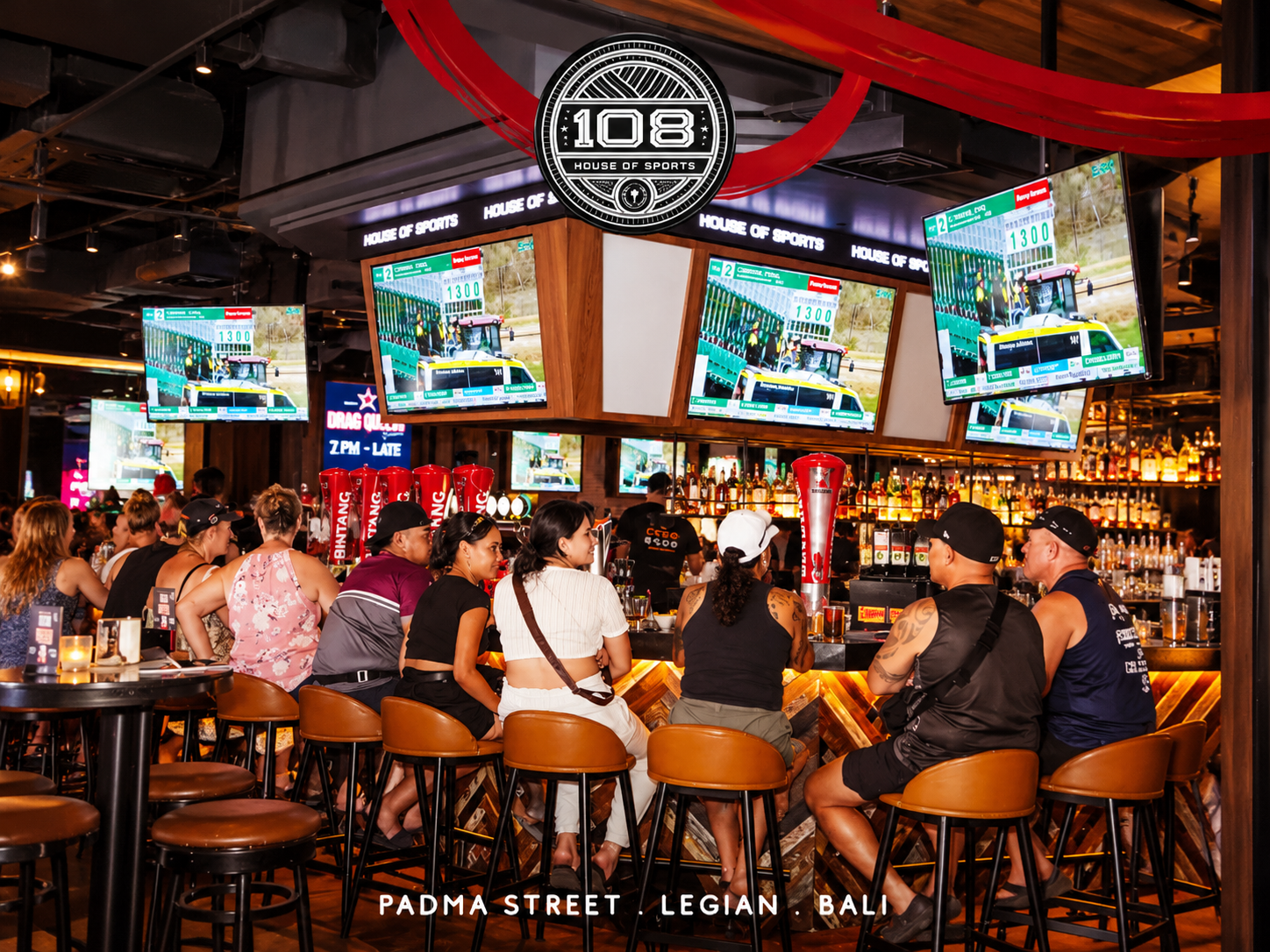 Interior of 108 House of Sports Bar in Bali with multiple screens showing live sports.