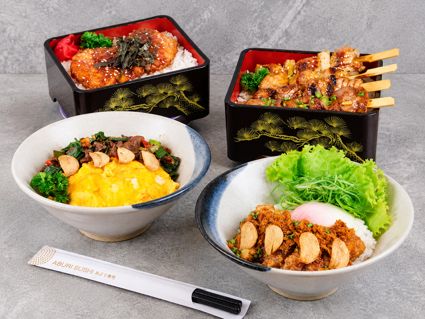 Japanese bento boxes filled with glazed meat, rice, vegetables, and assorted side dishes.