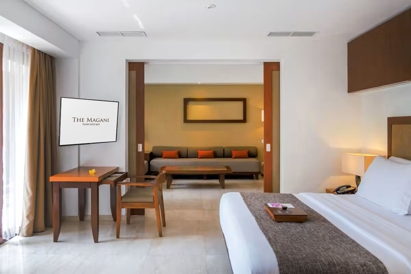Magani Suite living area with sofa and modern wall decor.